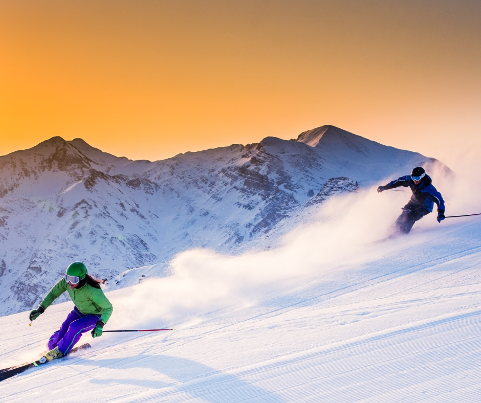 Emoción compartida en la nieve: Dos intrépidos aventureros deslizándose por las majestuosas pistas de esquí