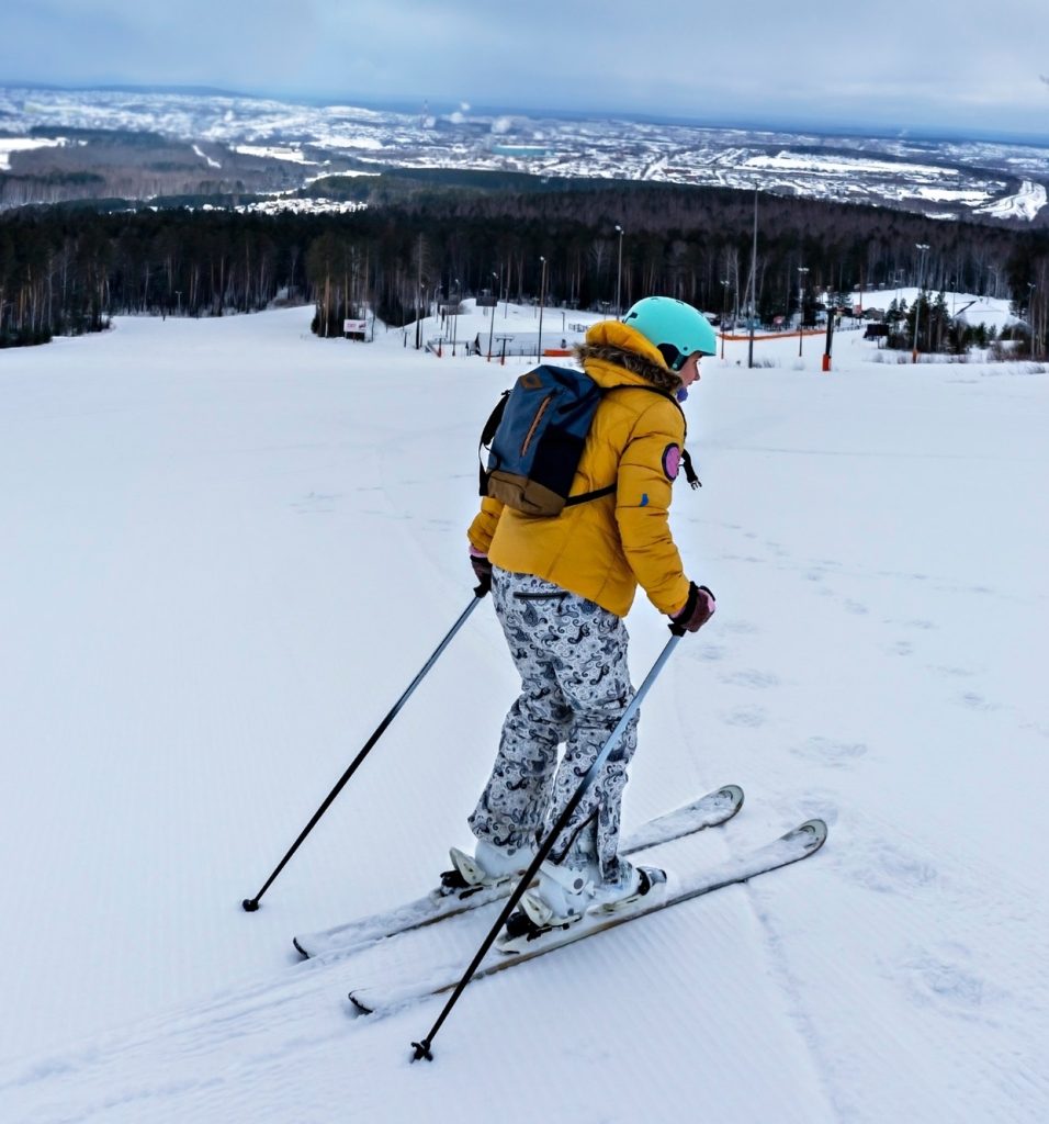 young-woman-in-yellow-jacket-skiing-on-a-ski-slope.jpg